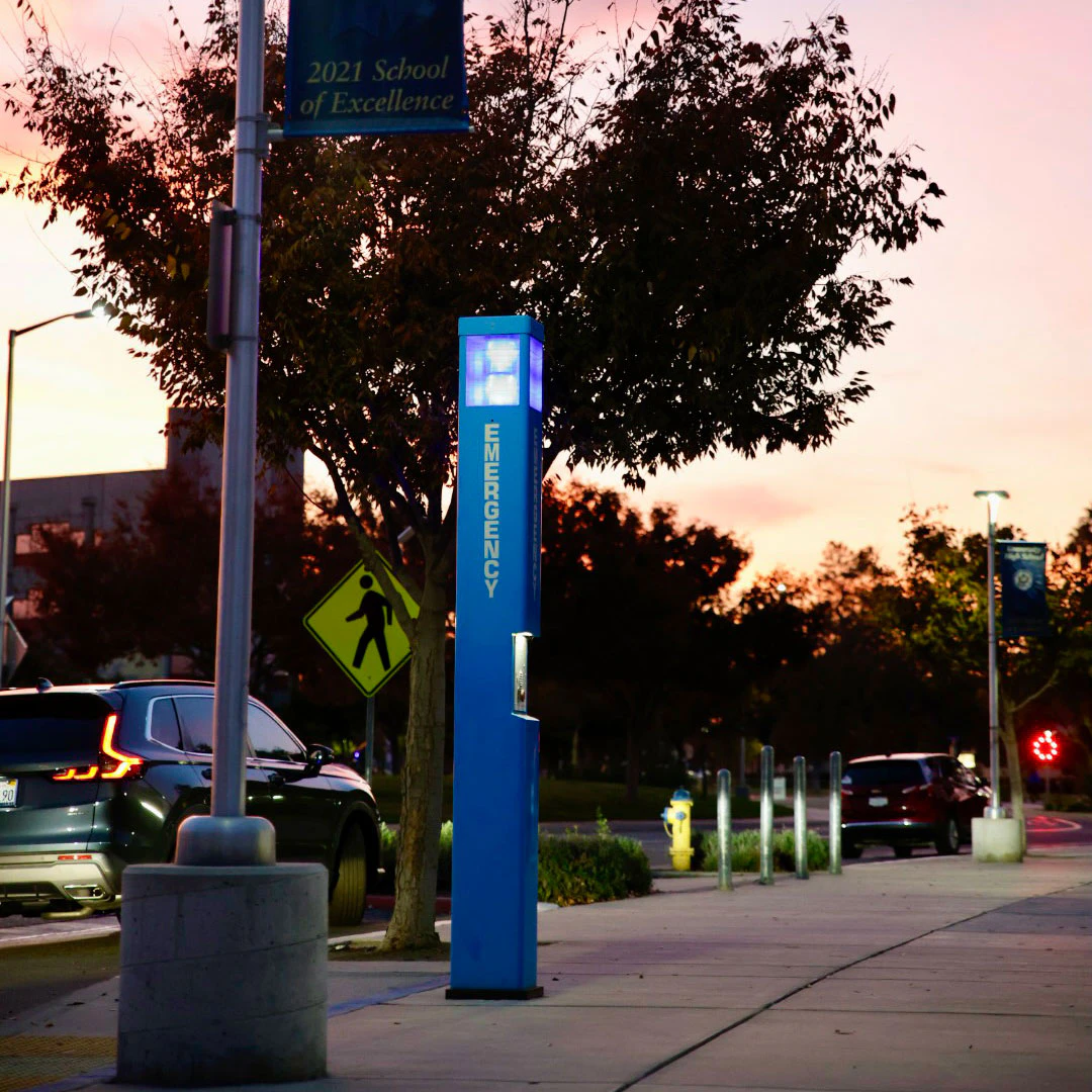 Blue outdoor emergency call box used for commercial safety and compliance communication systems